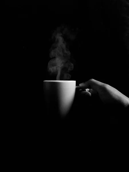 Вертикальный Снимок Оттенках Серого Руки Держащей Чашку Парящего Кофе — стоковое фото