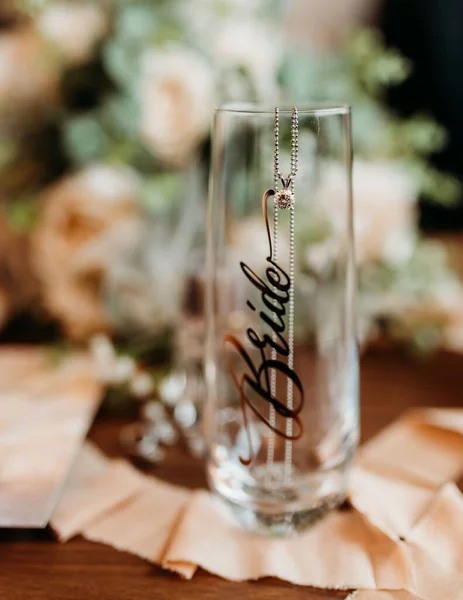 リボンに の文字と背景に結婚式の花束を持つガラスの垂直ショット — ストック写真