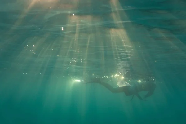 澄んだ海で日没の間に潜水する若い男のクローズアップショット — ストック写真