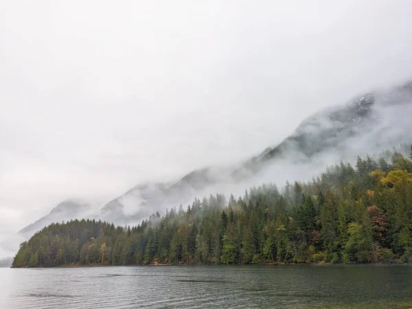 Klidné Jezero Obklopené Zamlženým Lesem Horami Během Dne — Stock fotografie