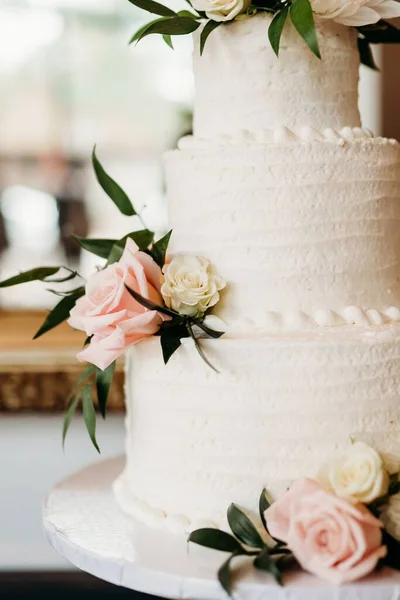 結婚式のために用意された花で飾られた美しい白いウェディングケーキ — ストック写真