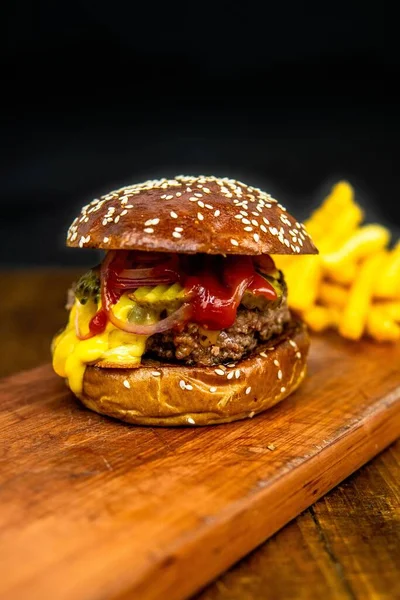 Pionowe Ujęcie Kanapki Burgerem Frytkami Drewnie Odizolowanym Czarnym Tle — Zdjęcie stockowe