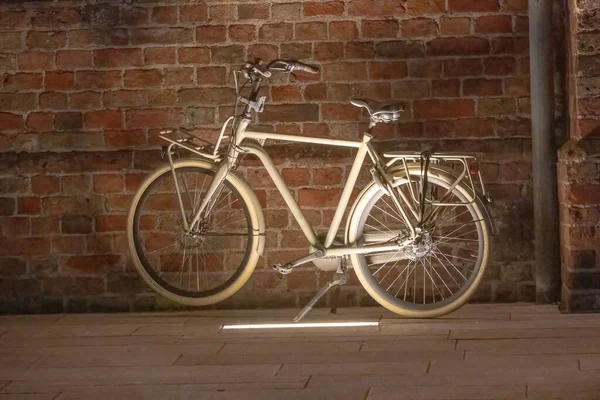 在阳光下的砖墙前停放着一辆复古米色自行车 — 图库照片