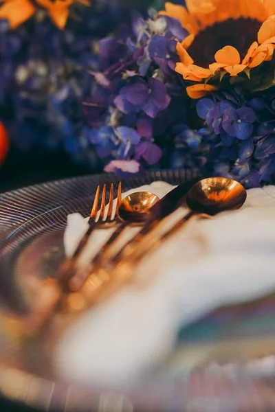 テーブルの上の美しい花の装飾に囲まれたプレートや道具の垂直閉鎖 お祝いの準備 — ストック写真