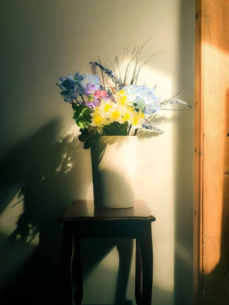 Sandalyede Renkli Çiçeklerle Dolu Beyaz Bir Vazonun Dikey Görüntüsü — Stok fotoğraf