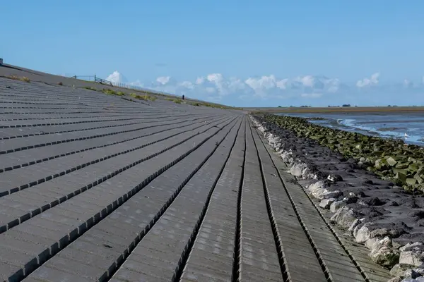 stock image The view of Sea-dike and colored stones before the sea waves on a sunny day