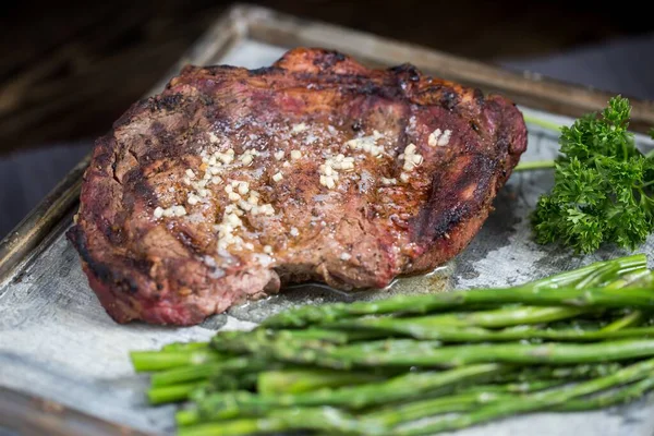 Closeup Seasoned Steak Tray Greens Blurry Background — Stock Photo, Image