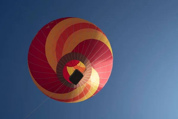 在晴朗的天空中 一个红色和黄色热气球的低角度镜头 — 图库照片