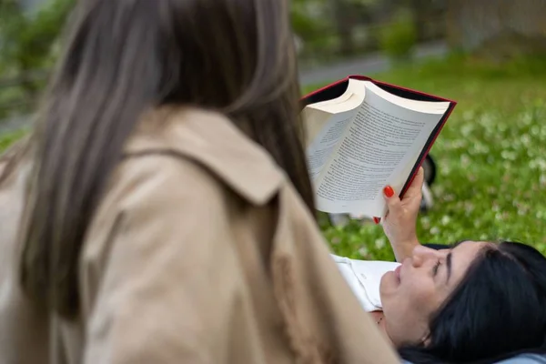 Una Chica Acostada Sobre Las Piernas Amigo Mientras Lee Libro — Foto de Stock