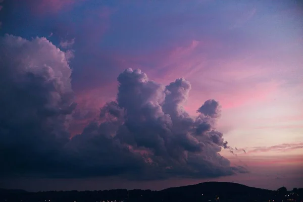 Büyük Beyaz Bulutlar Pembe Günbatımı Gökyüzünde Tepe Siluetleri Altında — Stok fotoğraf
