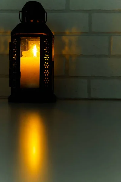 Лампа Освітленою Свічкою Світлом Відображеним Столі Цегляною Стіною Фоні — стокове фото