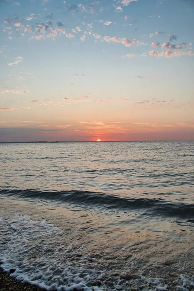 Вертикальный Снимок Заходящего Солнца Красочного Неба Над Волнистым Морем — стоковое фото