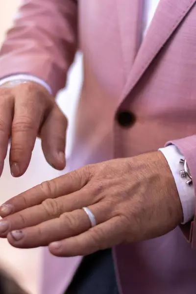 新郎手的垂直照片 手上戴着一枚戒指 身穿粉色西服 — 图库照片