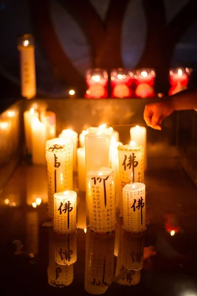 一支垂直的蜡烛 上面有韩语的音符 还有一个人在点燃另一支蜡烛 — 图库照片