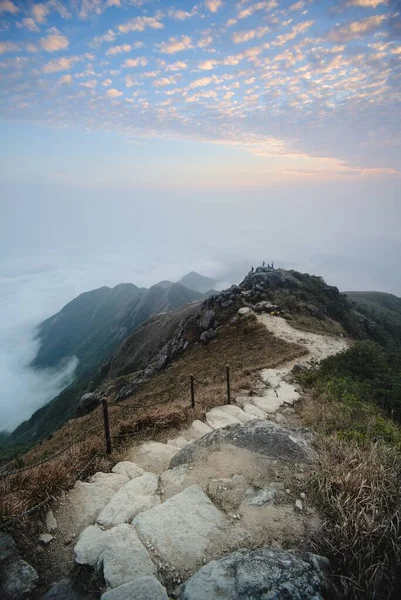 在高山顶上的一条以云彩为背景的狭窄人行道上的一个垂直截图 — 图库照片