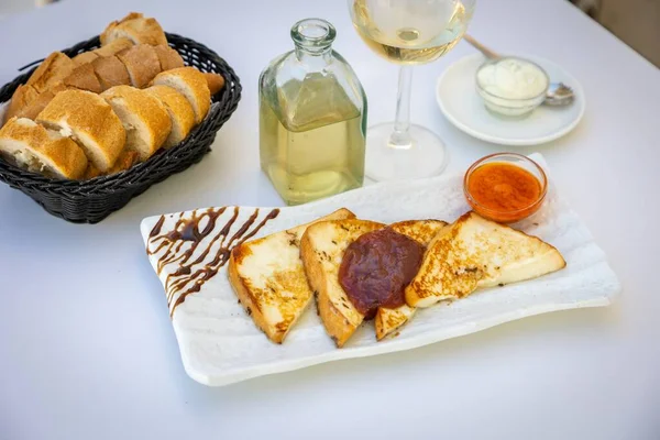 テーブルの上にジャムと白ワインとフライドポテトトーストのクローズアップショット ロイヤリティフリーのストック写真