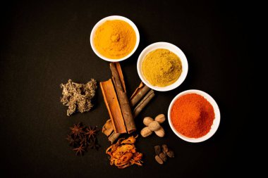 Hint garam masala ya da siyah arka planda izole edilmiş baharat tozu kasesinin üst görüntüsü.