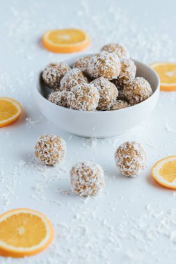 Beyaz arka planda hindistan cevizi ısırığı ve portakallarının dikey görüntüsü