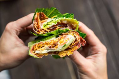 Yüksek açılı, marul sarılı ellerin yakın çekimi.