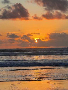 Akşamları denizin üzerinde gün batımının dikey görüntüsü.