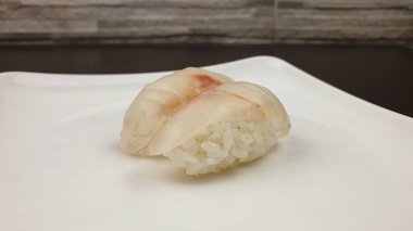 Bir Nigirzushi 'nin servis edildiği beyaz bir tabağın yakın çekimi.