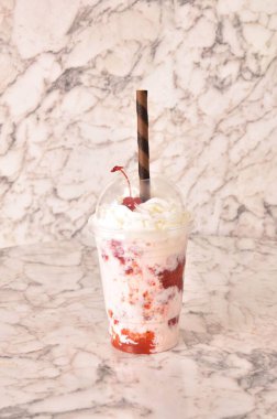 Mermer bir yüzeyde çilekli milkshake 'in dikey görüntüsü.