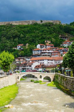 Kosova 'nın Prizren kentindeki nehrin üzerindeki eski taş kemer köprüsünün dikey hava görüntüsü