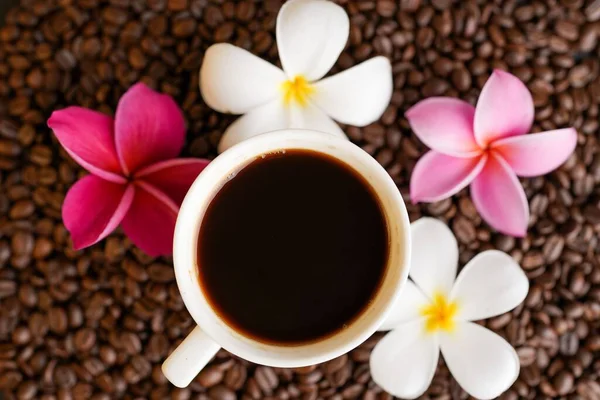 Zbliżenie Filiżanki Kawy Różowymi Białymi Kwiatami — Zdjęcie stockowe