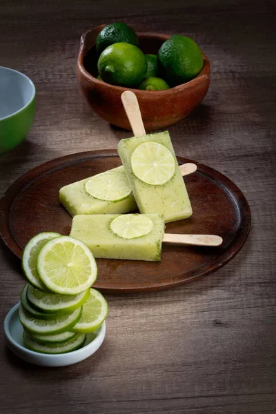 Vertical Shot Lime Flavor Popsicles Plate Surrounded Full Sliced Limes — Stock Photo, Image