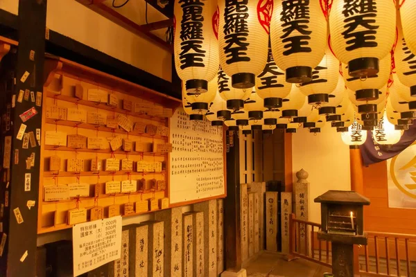 stock image The inside of a Japanese cafe with lots of light yellow lamps hanging from the ceiling with wooden decorations