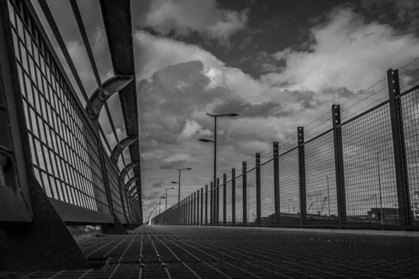 Grayscale Shot Caged Bridge Cloudy Sky — Stock Photo, Image