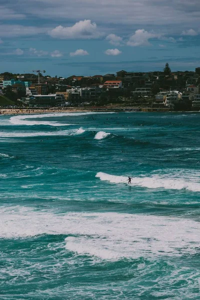 一个冲浪运动员骑在波浪上的垂直镜头 澳大利亚邦迪海滩 — 图库照片