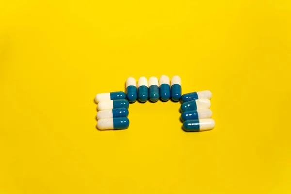 Μπλε Και Λευκά Χάπια Απομονώνονται Κίτρινο Φόντο — Φωτογραφία Αρχείου