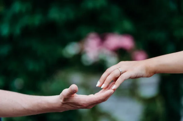 男性の指に触れる結婚指輪を持つ女性の手 — ストック写真