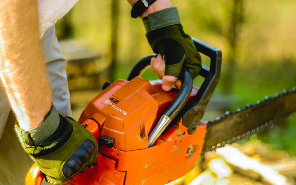 Closeup Shot Person Holding Orange Chainsaw Gear Cutting Wood — Stock Photo, Image