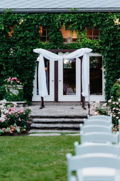 結婚式の準備ができているガラスのドアと椅子の列の前に祭壇の垂直ショット — ストック写真