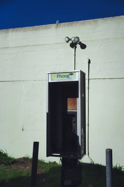 加利福尼亚州北部一座废弃的建筑物上的一部电话的垂直截图 — 图库照片