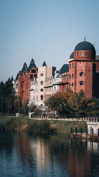 Pionowe Ujęcie Średniowiecznych Budynków Brzegu Rzeki Przed Niebieską Panoramą — Zdjęcie stockowe