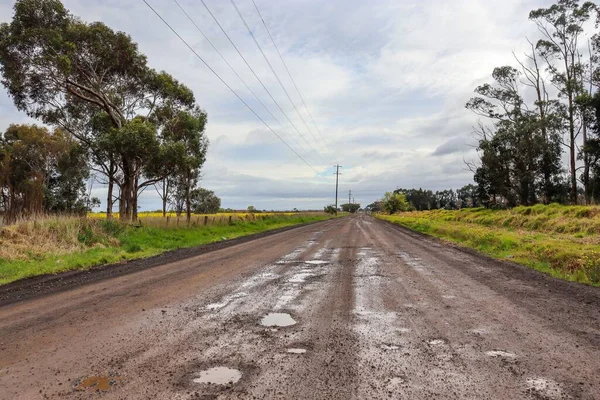 stock image A scenic view of a muddy road after the rain in a rural area in cloudy sky background