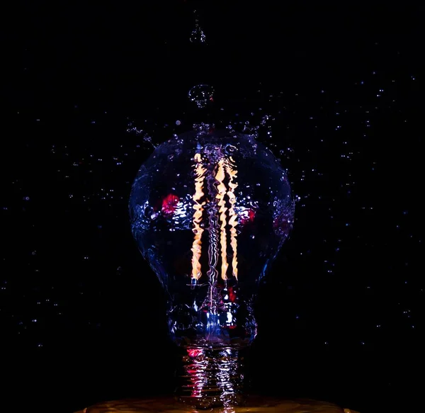 Вертикальный Кадр Водяного Брызга Лампочке Темном Фоне — стоковое фото