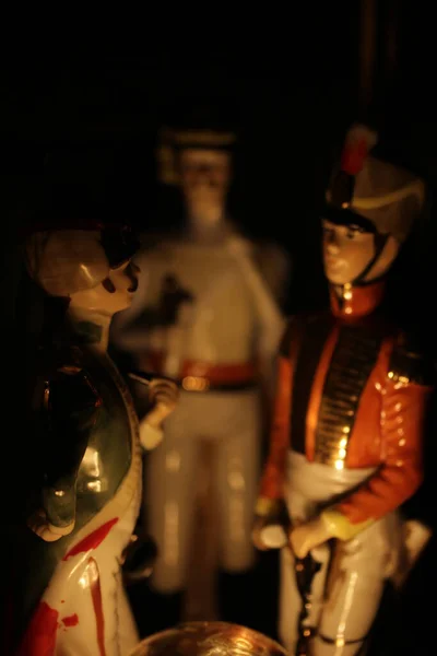 三个拿破仑时代的士兵瓷像布置得好像被篝火点着似的 — 图库照片