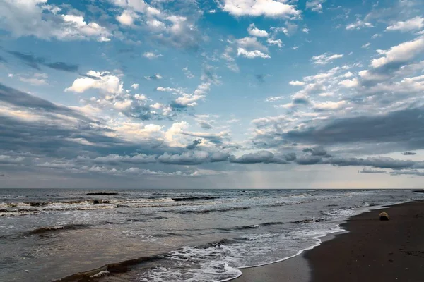 一张美丽的海滨照片 在戏剧化的天空下荡漾着海浪 — 图库照片