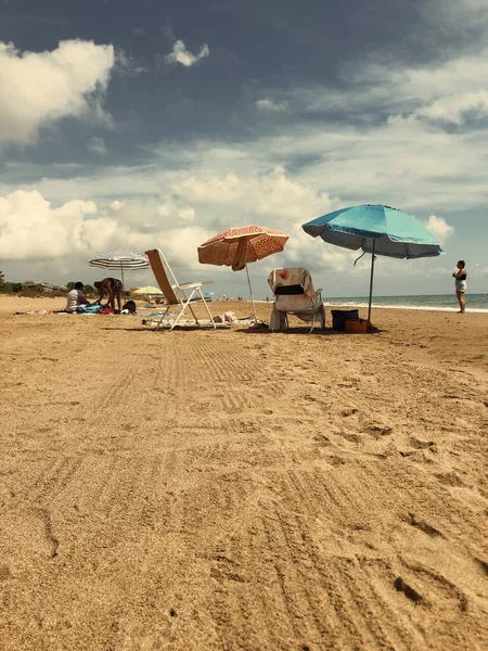加泰罗尼亚的一个沙滩上 人们拿着椅子和阳伞休息的垂直镜头 — 图库照片