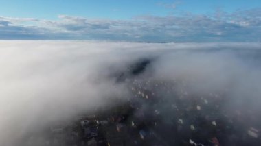 Yüzen beyaz bulutların üzerinde açık mavi, güneşli bir gökyüzünün havadan görünüşü.