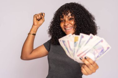 beautiful young african woman holding some money rejoices clipart