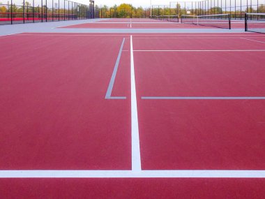 İnanılmaz kırmızı tenis kortu, beyaz çizgiler ve gri penyball çizgileri.