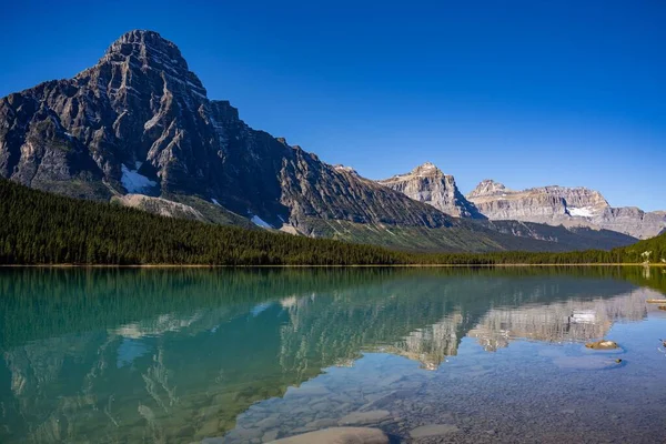 Nádherný Výhled Průzračný Povrch Horského Jezera Věčně Zeleným Lesem Zasněženými — Stock fotografie