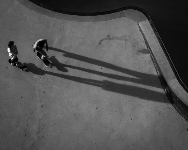 Беспилотник Серая Фотография Фигуристов Скейт Парке Отбрасывающих Длинные Тени Городе — стоковое фото