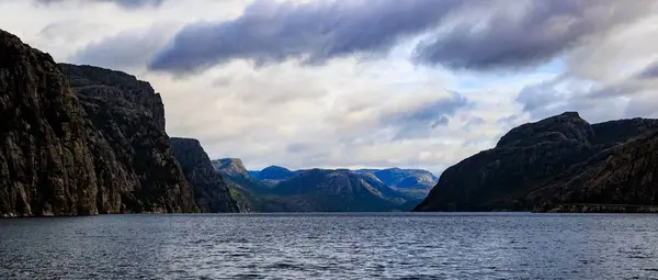 曇り空の岩の山に囲まれた穏やかな水の湖の美しい風景 — ストック写真