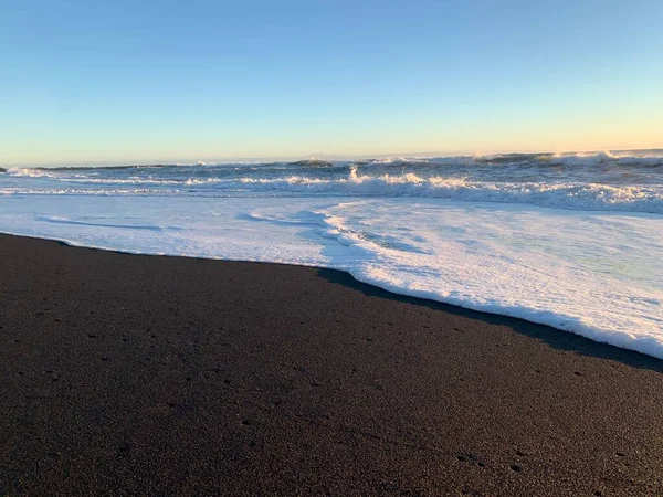 冰岛的沙滩上 在美丽的落日下 泡沫般的浪花冲刷着沙滩 — 图库照片